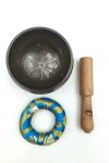 Cuenco tibetano artesanal con símbolo Om Mani, mantras grabados, mazo de madera y cojín decorativo para meditación y relajación.