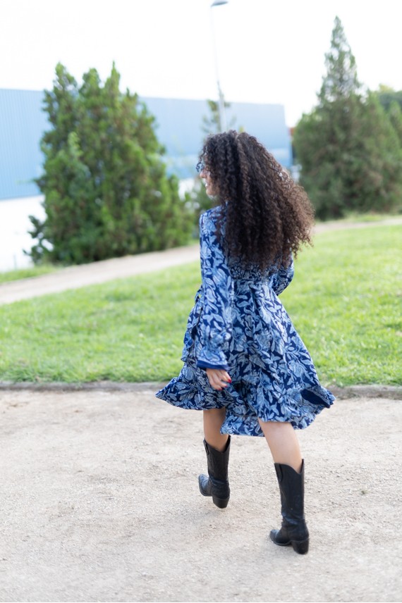 Vestido pareo estampado azul de estilo boho visto de perfil, con manga larga y falda midi con volante.