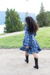 Vestido pareo estampado azul de estilo boho visto de perfil, con manga larga y falda midi con volante.