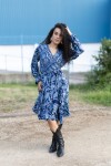 Vestido midi estampado azul marino visto de espalda, con cintura ajustable y motivos florales en tonos azules
