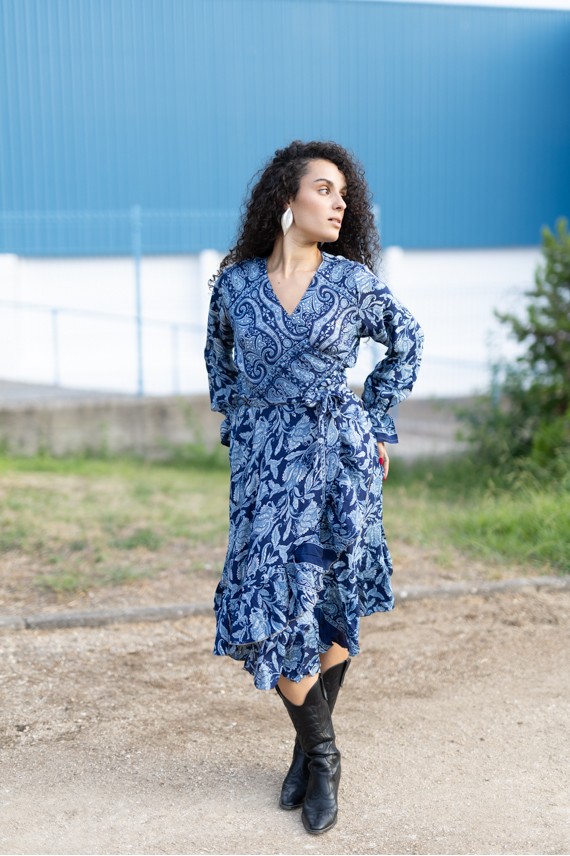 Vestido pareo midi boho azul en movimiento, con estampado vegetal, manga larga y falda fluida.
