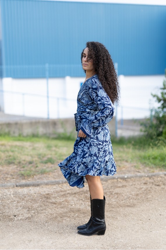 Vestido estampado azul boho visto de espalda, con motivos florales y vegetales y bajo con volante.