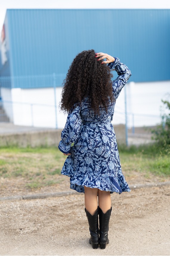 Vestido estampado azul boho visto de espalda, con motivos florales y vegetales y bajo con volante.