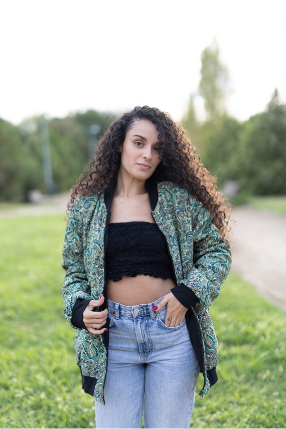Chaqueta bomber de seda con estampado paisley verde turquesa, azul y ocre con acabados negros.