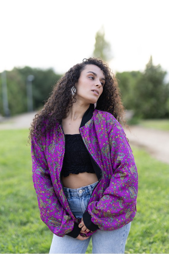 Chaqueta bomber de seda fucsia con estampado paisley floral multicolor y detalles negros.