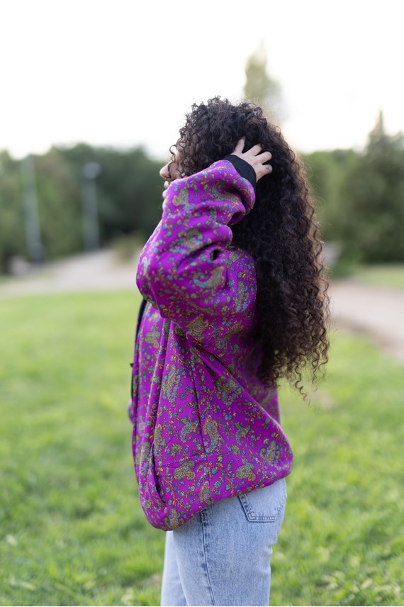 Chaqueta de seda fucsia con estampado paisley multicolor y acabados negros.