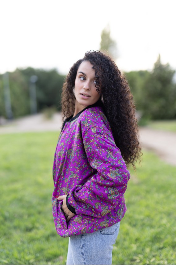 Chaqueta bomber fucsia estampada de seda vista de perfil con manga amplia.