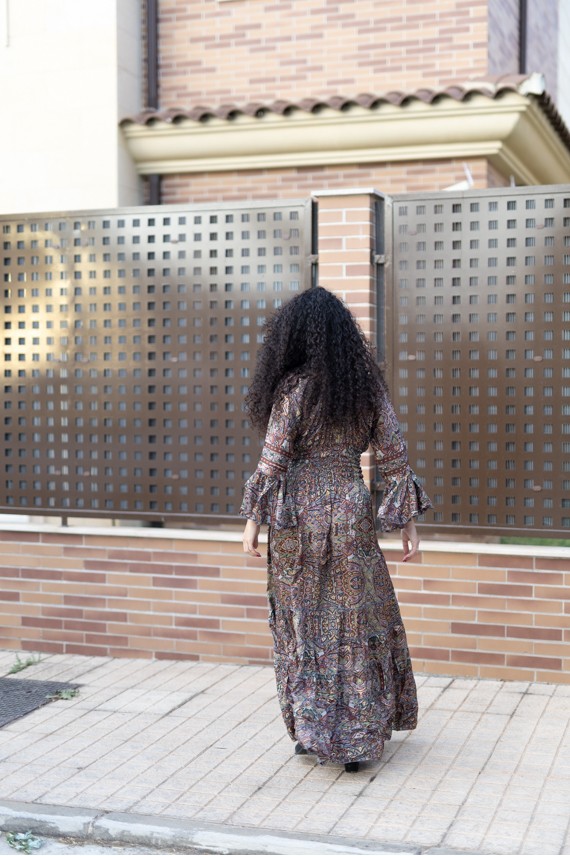 Vista trasera de vestido largo estampado paisley con cintura elástica y falda de vuelo.