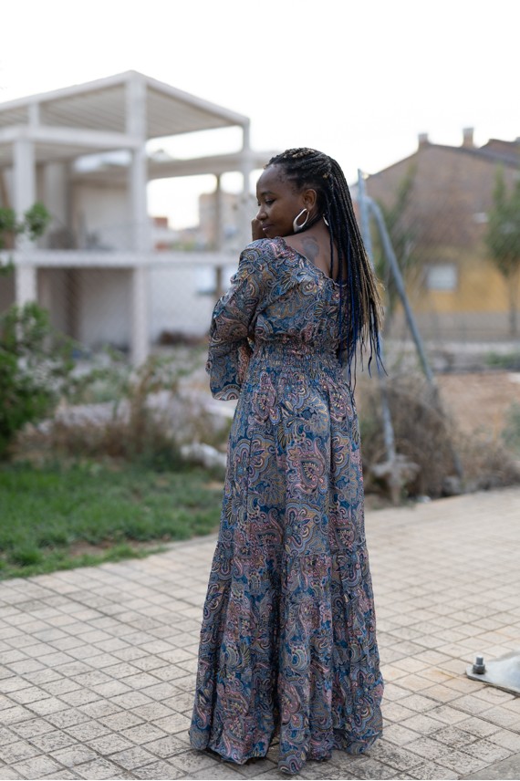 Vista trasera de vestido largo paisley azul con cintura elástica, mangas con volante y falda de amplio vuelo.