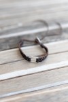 Pulsera Selva de cuero marrón trenzado con eslabón metálico rectangular plateado, estilo boho.
