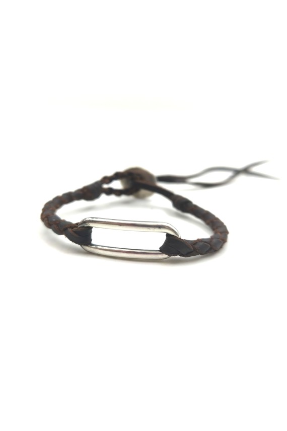 Pulsera Camino de cuero marrón trenzado con eslabón metálico alargado de acabado plateado.
