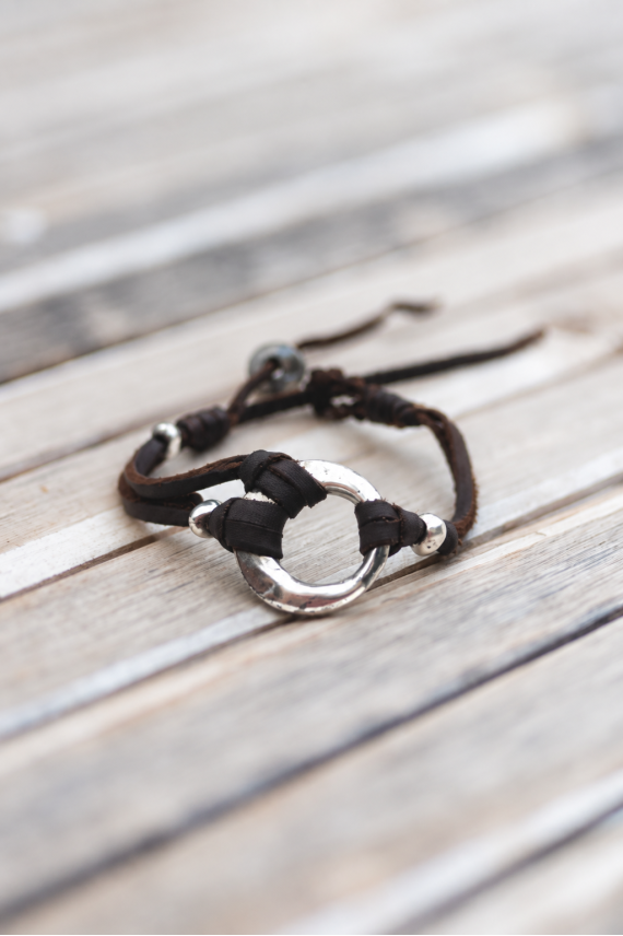 Pulsera Luna de cuero marrón con aro metálico plateado y detalles anudados, diseño boho artesanal Samarkanda.