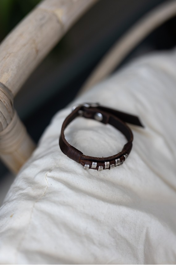 Pulsera Tribu de cuero marrón con pequeños apliques metálicos plateados de inspiración étnica.