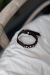 Pulsera Tribu de cuero marrón con pequeños apliques metálicos plateados de inspiración étnica.
