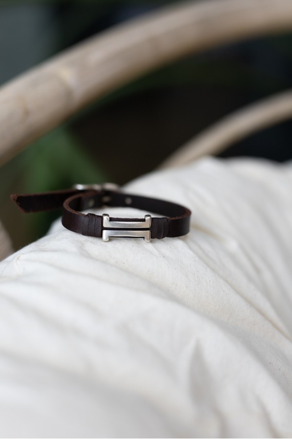 Pulsera Horizonte de cuero marrón con pieza metálica geométrica de doble línea y acabado plateado.