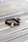 Pulsera Eclipse de cuero marrón con aro metálico circular texturizado de acabado plateado, estilo boho artesanal.