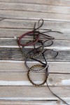 Pulseras Sendero de cuero marrón trenzado con hilos de diferentes colores, estilo boho hippie artesanal.