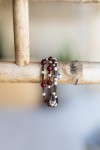 Pulsera Fuego de cuero marrón con cuentas rojas, abalorios y corazones metálicos de estilo boho.