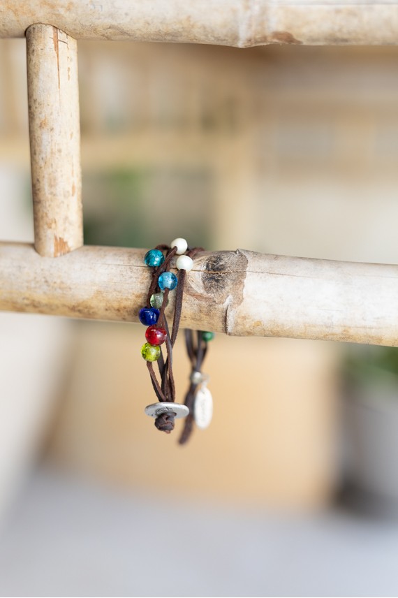 Pulsera Oasis de cuero marrón con varias tiras y cuentas multicolor de estilo boho artesanal.