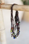 Collar artesanal de cuero con pequeñas gemas de colores, diseño multitiras estilo boho.