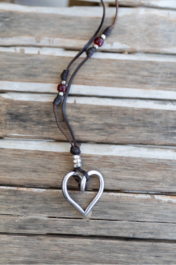 Collar de cuero marrón con corazón plateado, gemas de colores y cierre regulable.