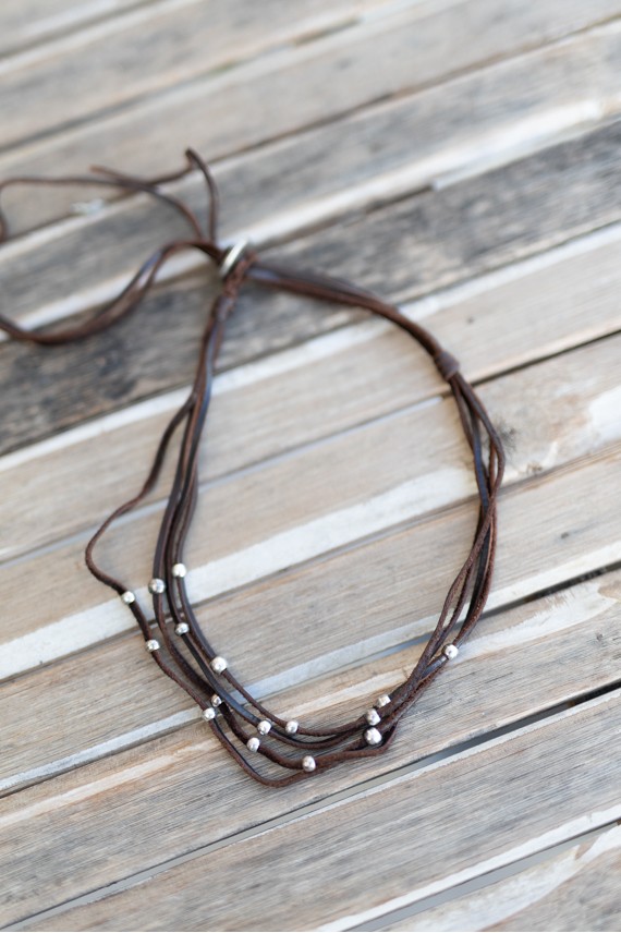 Collar de cuero multitiras con bolas de zamak plateadas y cierre regulable de estilo boho.