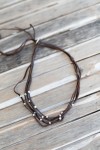 Collar de cuero multitiras con bolas de zamak plateadas y cierre regulable de estilo boho.