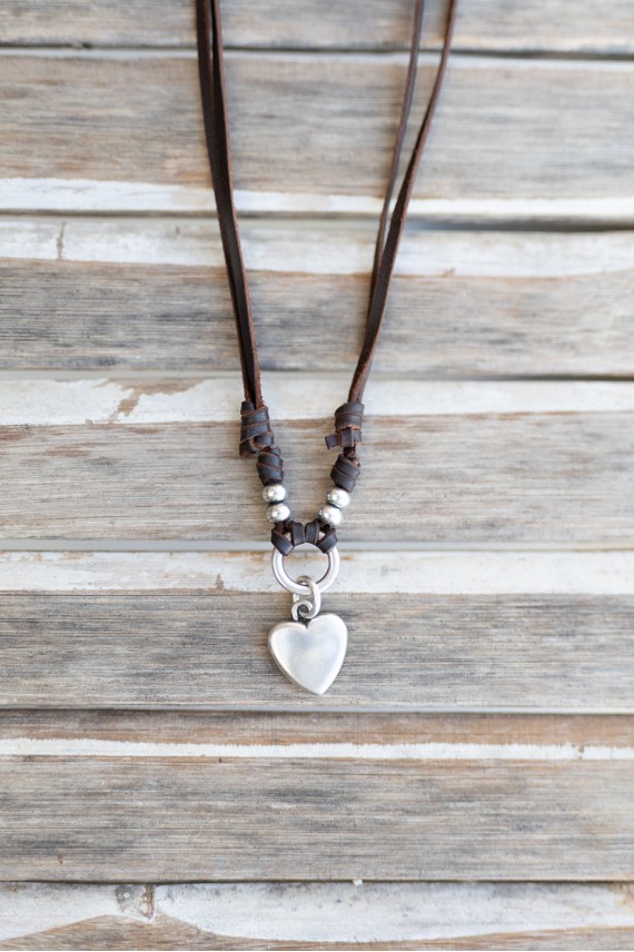 Collar de cuero marrón con corazón colgante de zamak, bolas metálicas y largo regulable.