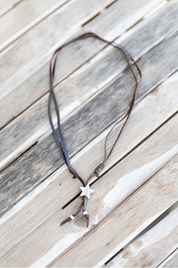 Detalle de collar de cuero con colgante estrella y bolas de zamak, estilo boho Samarkanda.