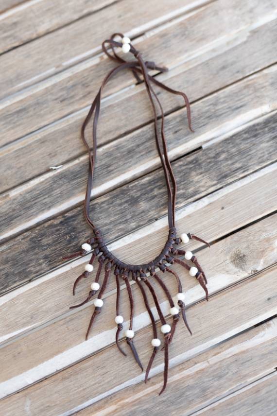 Collar de cuero hecho a mano con perlas blancas y tiras colgantes, diseño boho artesanal ajustable.
