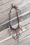 Collar de cuero hecho a mano con perlas blancas y tiras colgantes, diseño boho artesanal ajustable.
