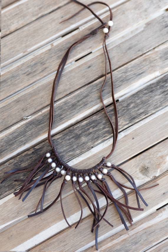 Collar de cuero hecho a mano con perlas blancas y largos flecos, diseño boho artesanal con nudo ajustable.
