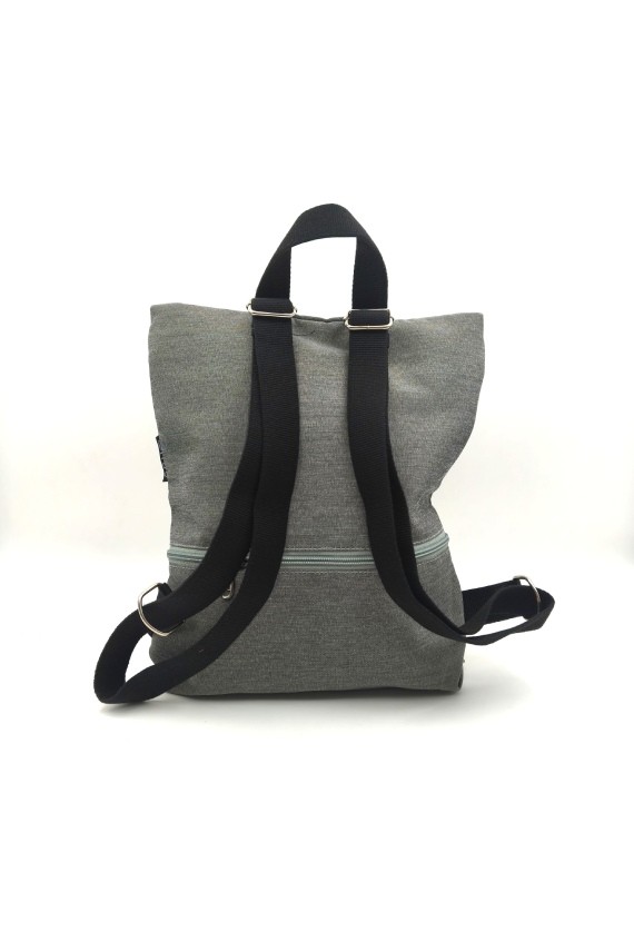 Parte trasera de mochila de algodón gris con asas negras regulables y bolsillo con cremallera.