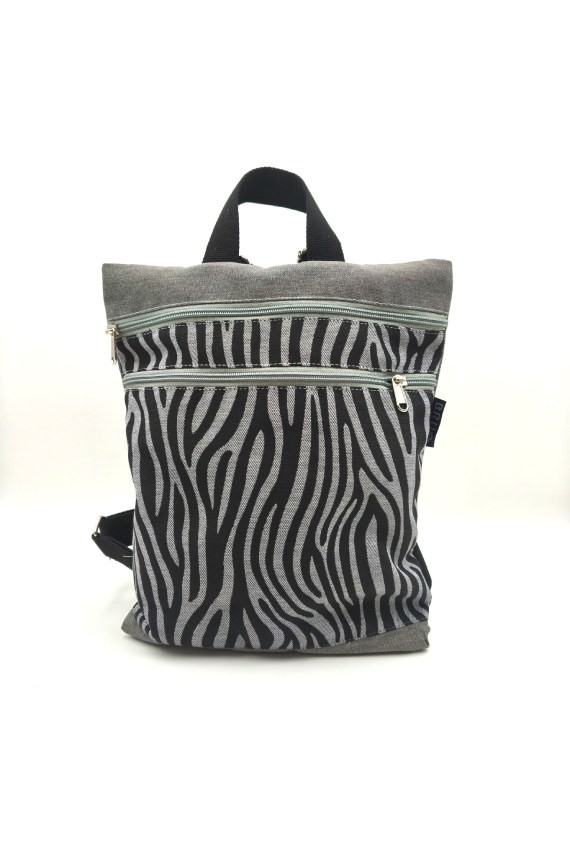 Mochila de algodón gris con estampado cebra negro y bolsillos frontales con cremallera.