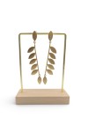 Pendientes largos de latón dorado con diseño de dos medias ramas enfrentadas y hojas, estilo boho.
