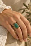 Anillo dorado con turquesa natural ovalada verde azulada, marco trenzado y detalles étnicos de Samarkanda.