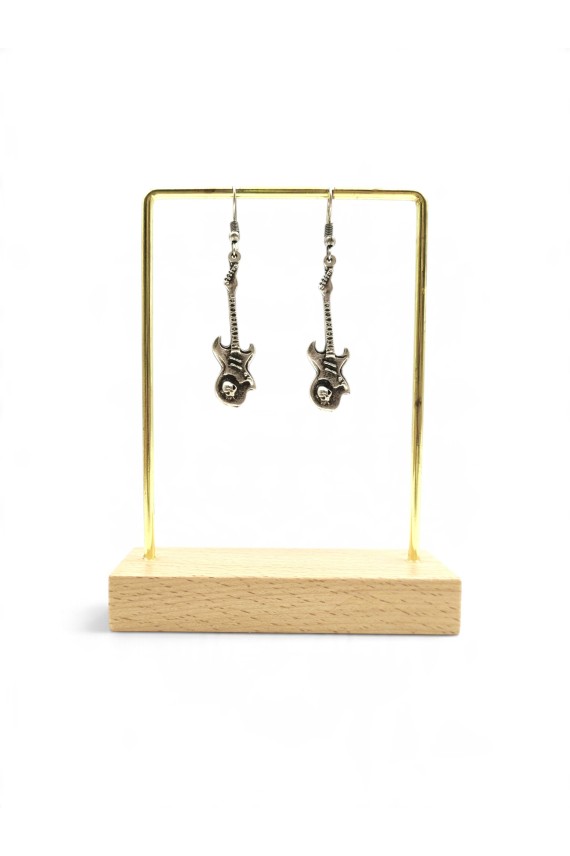 Detalle de pendientes colgantes de zamak con guitarra eléctrica, texturizada y calavera en relieve estilo rock vintage.