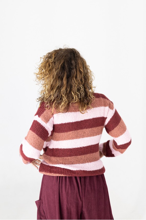 Vista trasera del jersey de punto a rayas rosa, teja y burdeos con cuello cisne, manga larga y bajo elástico.